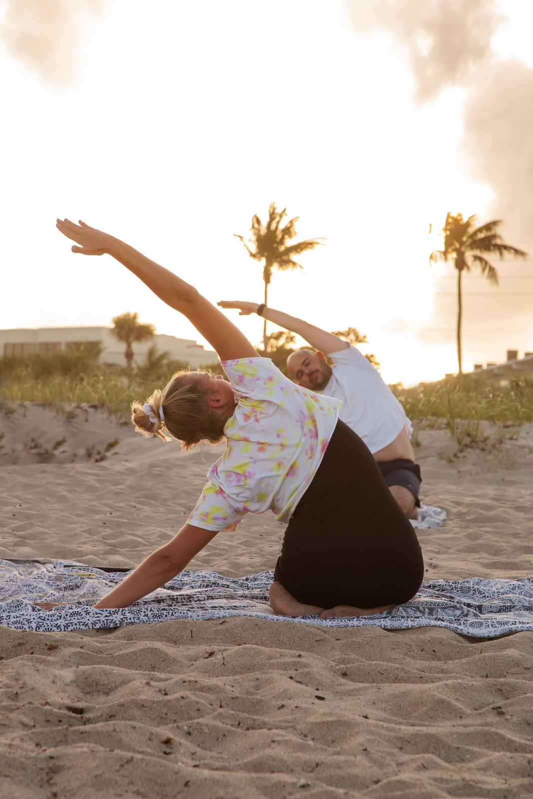 A guest stretching during a yoga class on the beach