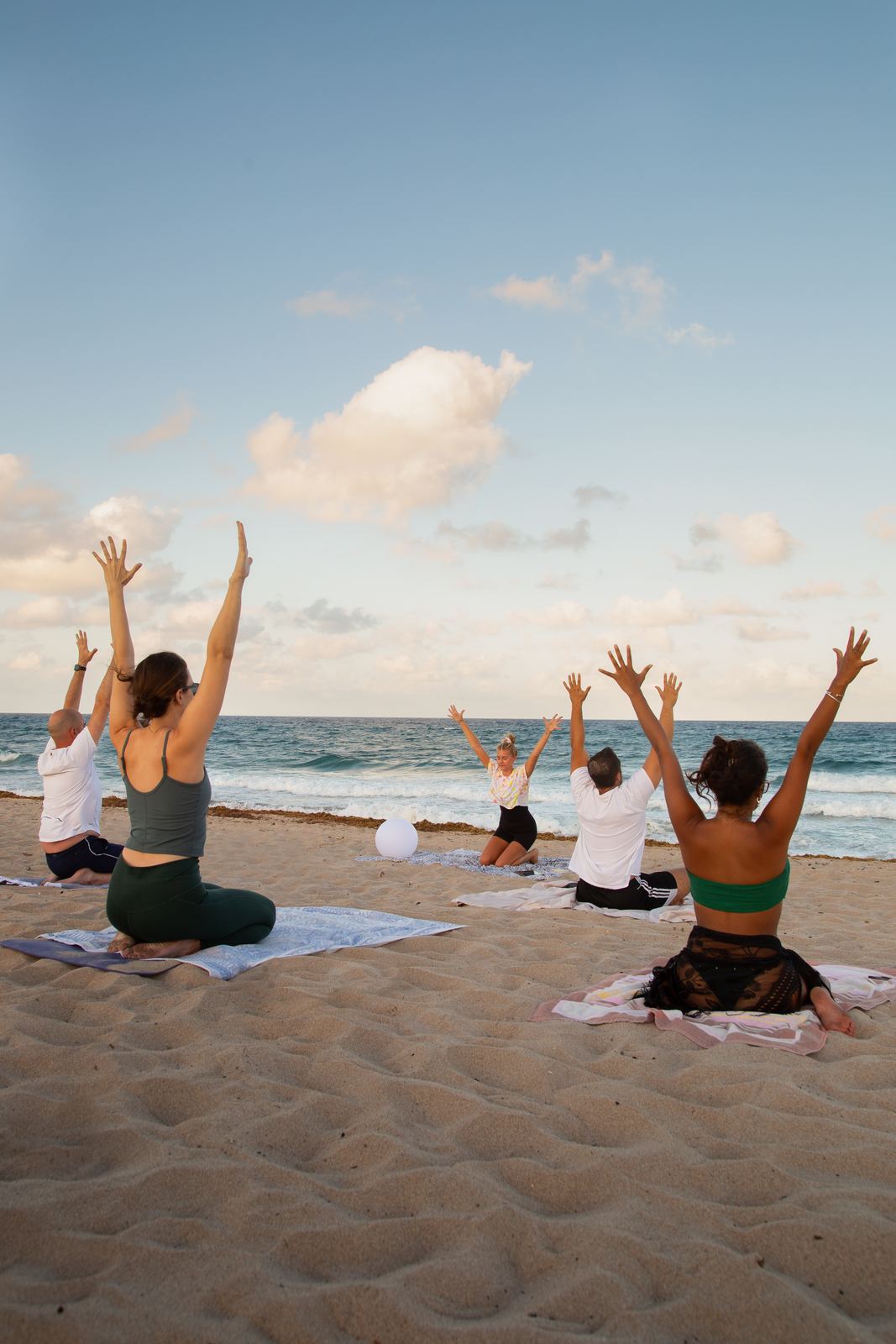 Students reaching overhead during an outdoor group yoga class
